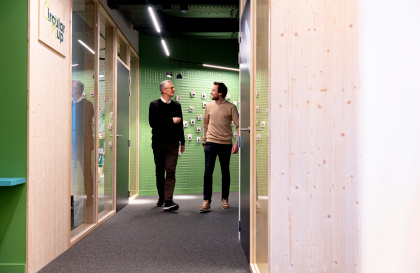 Two colleagues of Upgrade Estate standing in a hallway of Upgrade Estate, best workplace.